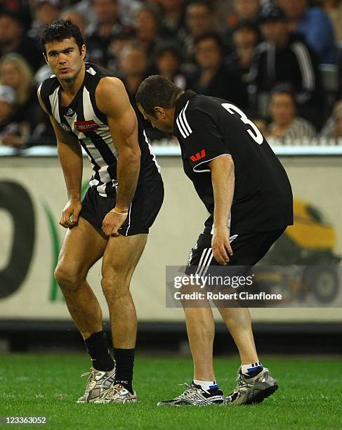 Chris Tarrant of the Magpies is taken from the ground during the round 24 AFL match between the Collingwood Magpies and the Geelong Cats at Melbourne...