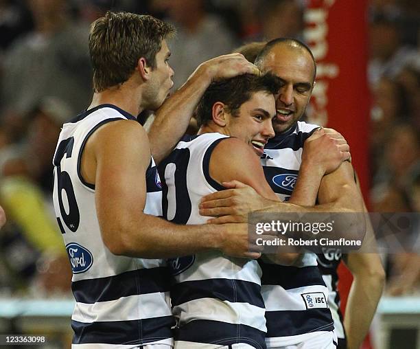 Daniel Menzel of the Cats celebrates his goal with Tom Hawkins and James Podsiadly during the round 24 AFL match between the Collingwood Magpies and...