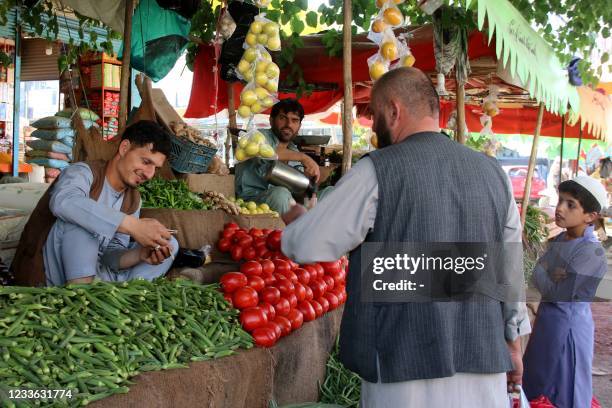 Street vendor sells vegetables at a roadside stall in a market in Kunduz on June 24, 2021.