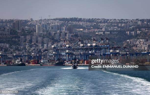 An Israeli military boat makes its way past cranes along the docks of the port of the northern city of Haifa, on June 24, 2021.