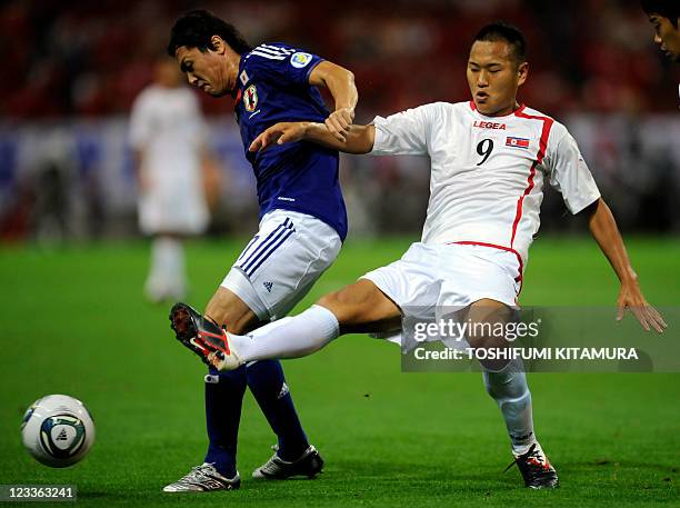 North Korean forward Jong Tae-Se fights for the ball with Japan's midfielder Yasuhito Endo during their 2014 World Cup Asian qualifilers in Saitama,...