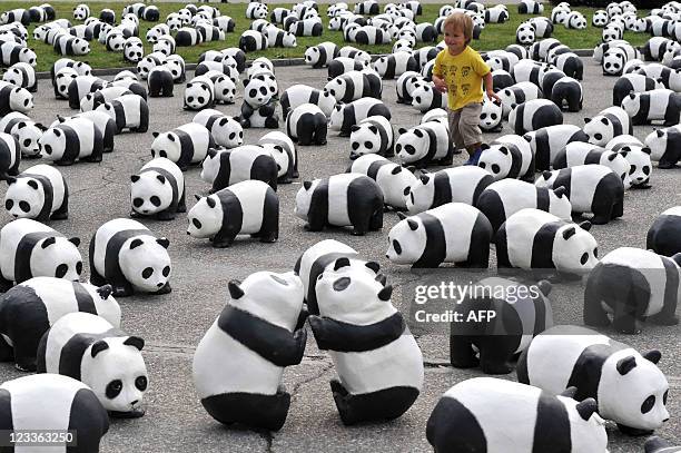 Child runs on September 2, 2011 amongst some of 1600 papier maches pandas set up on a place by the lake in Geneva by World Wildlife Fund members to...