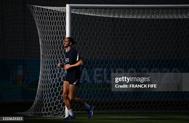 France's midfielder Adrien Rabiot jogs during a training session at the Nandor Hidegkuti stadium in Budapest on June 24, 2021 as part of the UEFA...