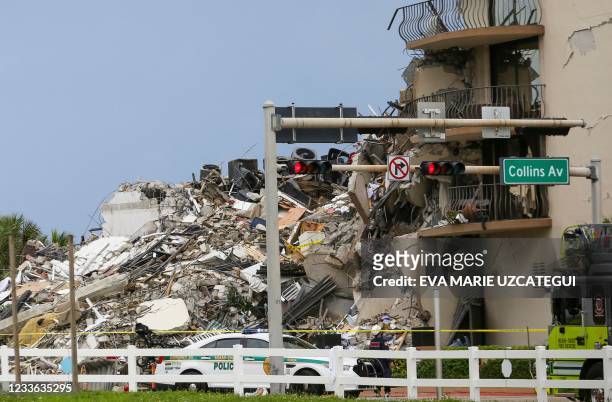 Police car is parked in front of debris from a partially collapsed building in Surfside north of Miami Beach, on June 24, 2021. - A high-rise...