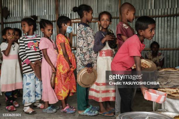 Children, who fled the violence in Ethiopia's, Tigray region, wait in line for breakfast organized by a self-volunteer Mahlet Tadesse in Mekele, the...