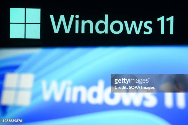 In this photo illustration a Windows 11 logo is seen on a smartphone and a pc screen in the background. Microsoft has presented Windows 11, new...
