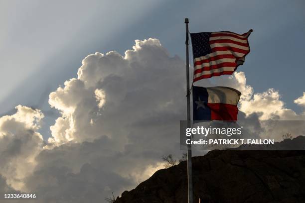 The United States Flag and Texas State Flag are displayed at Murchison Rogers Park along Scenic Drive at sunset on June 24, 2021 in El Paso, Texas.