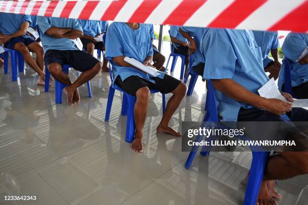 Inmates line up to receive doses of the Sinopharm Covid-19 coronavirus vaccine at Chonburi Central Prison on June 25, 2021.