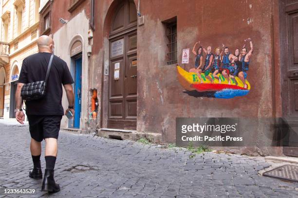 Man passing by the wall with mural made by Italian street artist Harry Greb named "Enjoy - Tutti al mare" in via dei Montecatini in Rome featuring...