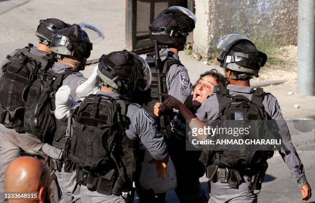 Israeli security forces arrest an activist near a police checkpoint at the entrance of the Sheikh Jarrah neighbourhood in east Jerusalem, during a...