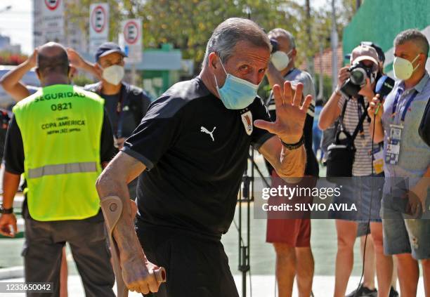 Uruguay's national football team head coach Oscar Washington Tabarez waves as he arrives at a training session at the Eurico Gaspar Dutra Stadium, in...
