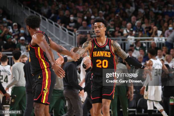 John Collins of the Atlanta Hawks high fives Solomon Hill of the Atlanta Hawks during Game 2 of the Eastern Conference Finals of the 2021 NBA...