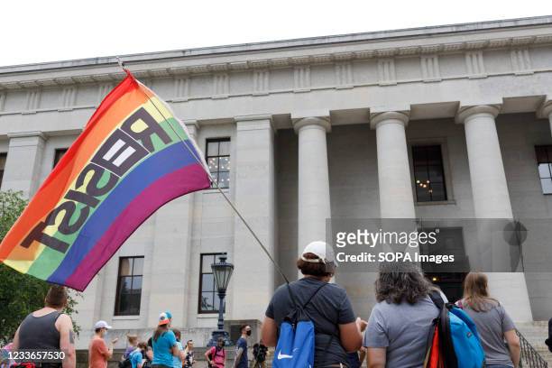 Protester holding a flag that reads resist during the demonstration. Transgender rights advocates stood outside of the Ohio Statehouse at noon to...