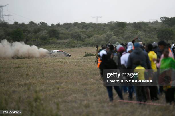 French driver Sebastien Ogier steers his Toyota Yaris WRC with French co-driver Julien Ingrassia as spectators look on during the SS13 stage of the...