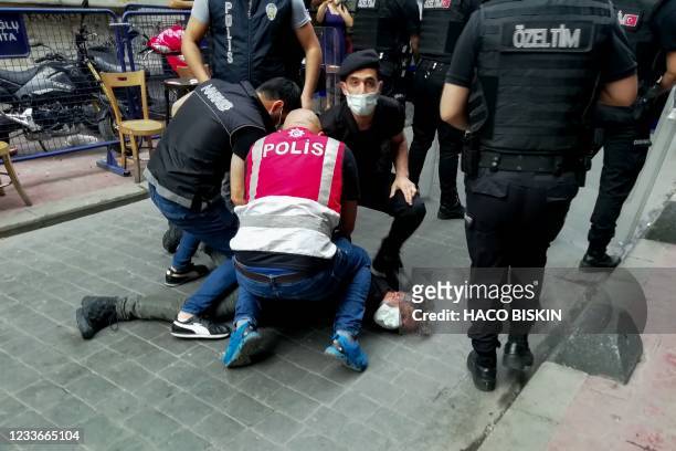 Police officers arrest AFP photographer Bulent Kilic while covering a Pride march in Istanbul that had been banned by authorities on June 26, 2021. -...