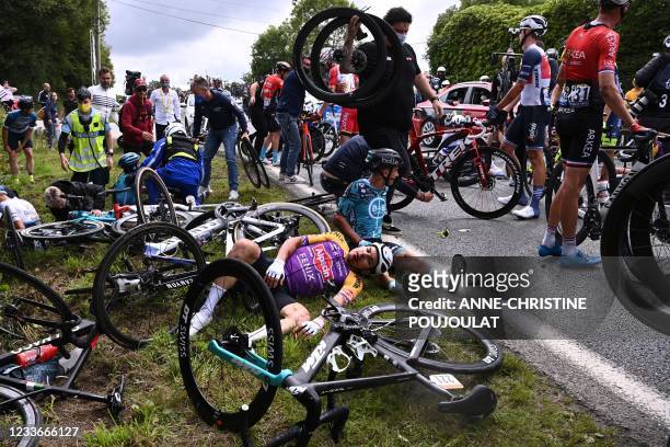 Team B&B KTM's Bryan Coquard of France and a Team Alpecin Fenix' rider lie on the ground after crashing during the 1st stage of the 108th edition of...