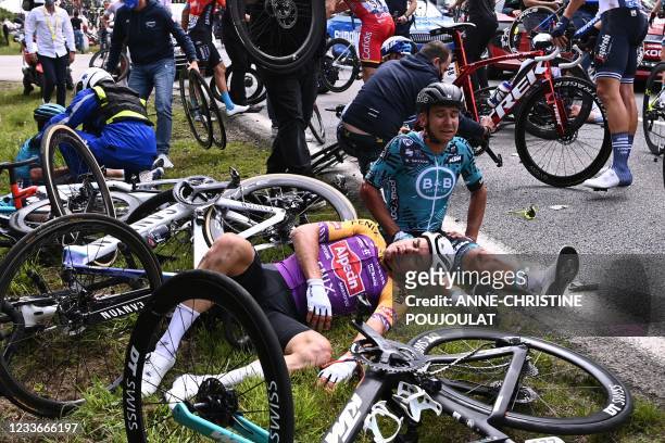 Team B&B KTM's Bryan Coquard of France and a Team Alpecin Fenix' rider lie on the ground after crashing during the 1st stage of the 108th edition of...