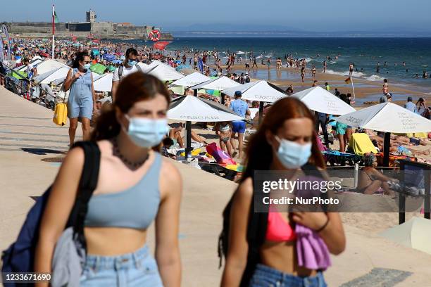 Beachgoers enjoy a summer day at the Carcavelos beach as the COVID-19 coronavirus pandemic continues, in Cascais, near Lisbon, Portugal, on June 26,...