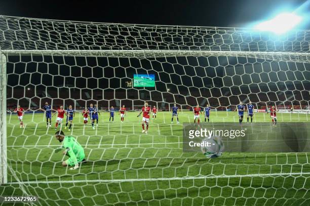 Ahly's defender Ali Maaloul scores from a penalty kick during the second leg of the CAF champions league semi-final football match between Egypt's...