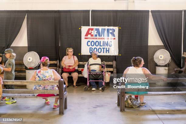 Attendees sit inside a cooling booth at the Shasta District Fair during a heatwave in Anderson, California, U.S., on Saturday, June 26, 2021. The...