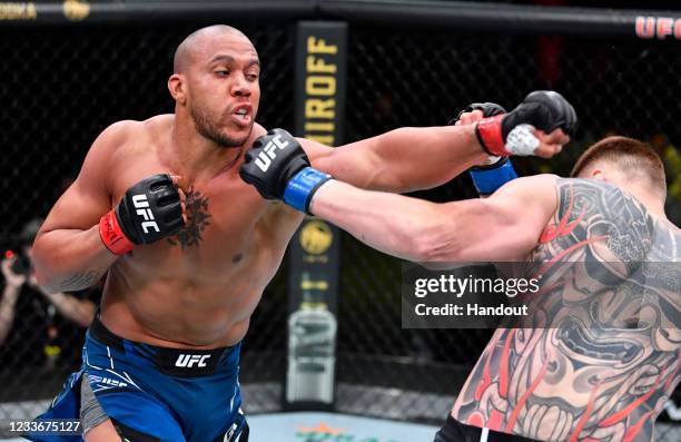In this handout photo provided by UFC, Ciryl Gane of France punches Alexander Volkov of Russia in a heavyweight fight during the UFC Fight Night...