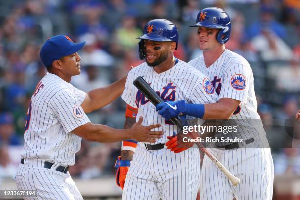 Dominic Smith of the New York Mets is held back by manager Luis Rojas and James McCann after arguing a called third strike during the eighth inning...