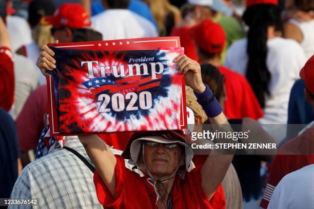 Trump supporter holds a "Trump 2020" sign as like many others she believes the election results were fraudulent, during a Trump campaign-style rally...
