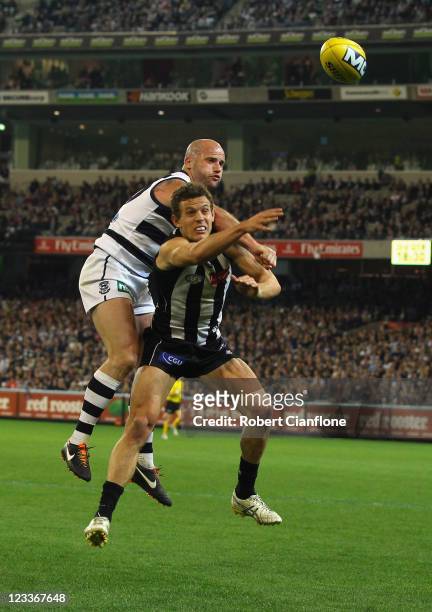 Luke Ball of the Magpies has the ball spoiled by Paul Chapman of the Cats during the round 24 AFL match between the Collingwood Magpies and the...