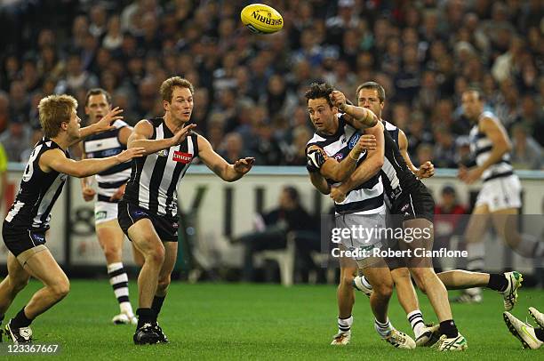 Jimmy Bartel of the Cats handballs during the round 24 AFL match between the Collingwood Magpies and the Geelong Cats at Melbourne Cricket Ground on...