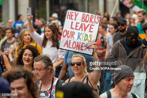 Woman holds a placard saying Hey Boris leave our kids alone while protesting against the covid-19 vaccine being available to children in the near...