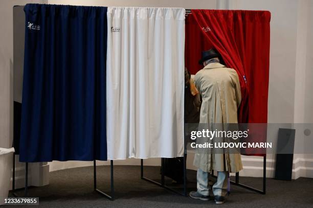 Voters enter a polling booth equipped with anti-covid curtains at a polling station in Le Touquet, for the second round of the French regional...