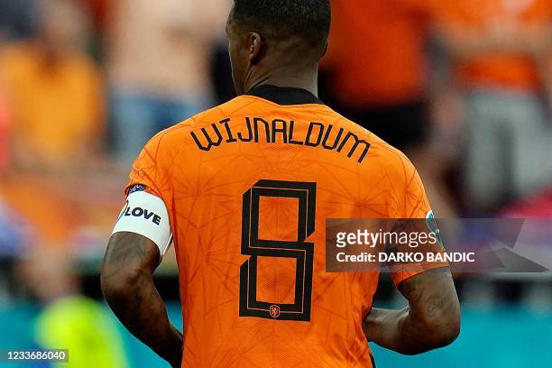 Netherlands' midfielder Georginio Wijnaldum wearing a captain's armband bearing the words "One Love" and a rainbow motif runs during the UEFA EURO...