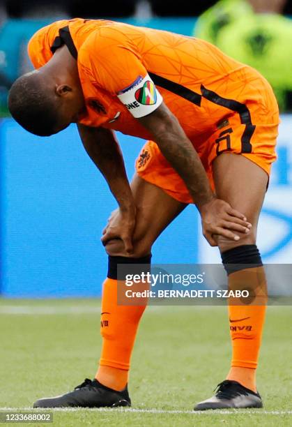 Netherlands' midfielder Georginio Wijnaldum wearing a captain's armband bearing the words "One Love" and a rainbow motif reacts at the end of the...