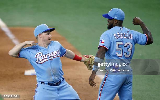 Brock Holt of the Texas Rangers and teammate Adolis Garcia celebrate their 4-1 win over the Kansas City Royals at Globe Life Field on June 27, 2021...