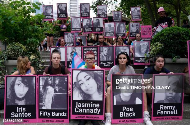 People sit in Bryant Park, holding photos of murdered transgender women and men, during the 3rd annual Queer Liberation March in New York June 27,...