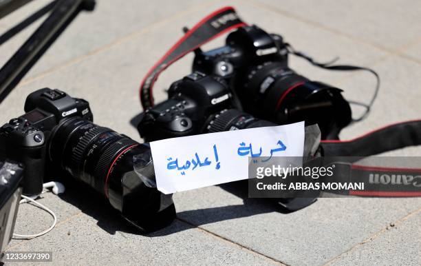 Photojournalists leave their cameras on the ground with a note reading in Arabic "Freedom of Press" during a protest outside the United Nations...
