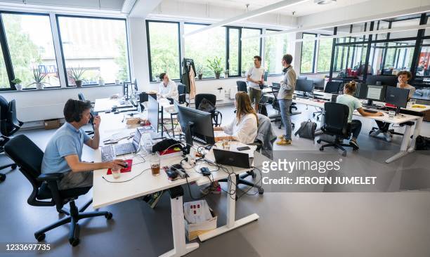 Employees at the online supermarket Picnic are seen at their desks in their office in Duivendrecht, northern Netherlands on June 28 after advice to...