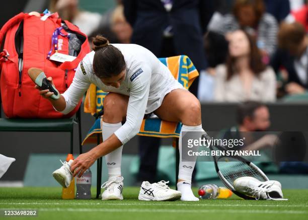 Romania's Monica Niculescu changes her shoes during a break in her match against Belarus' Aryna Sabalenka during their women's singles first round...