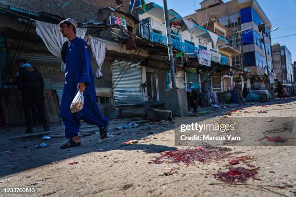 Pededstrian walk past the aftermath of a bomb explosion that killed 3 outside a bakery on Nawi Sarak Road, in Kandahar, Afghanistan, Friday, May 7,...