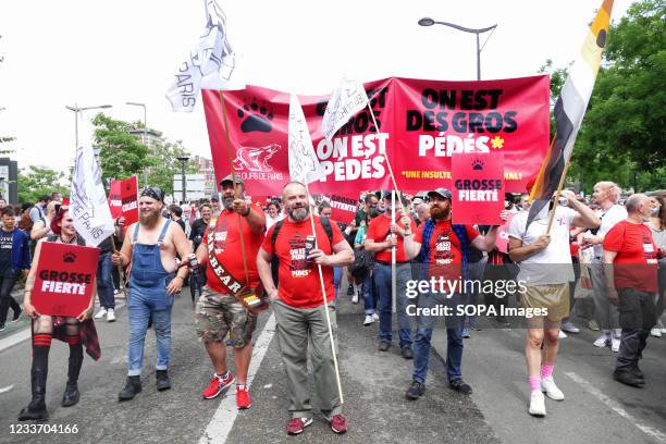 The group of bears, fat and bearded gay men hold banners and flags while marching through the Streets. Thousands of LGBT members and their supporters...