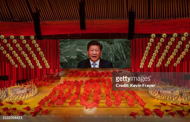 Chinese President and Chairman of the Communist Party Xi Jinping appears on a large screen as performers dance during a mass gala marking the 100th...