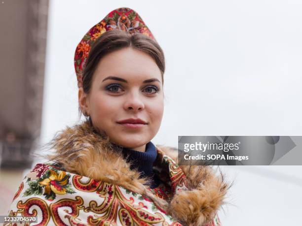 Young lady in a traditional Russian costume at the festival. Concerts of classical, folk music and bell ringing, theatrical performances, painting of...