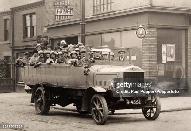 Vintage postcard featuring a group enjoying an outing by hackney carriage or charabanc, circa 1912.