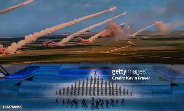 Performers dressed as military perform in front of a screen showing rockets being launched during a mass gala marking the 100th anniversary of the...