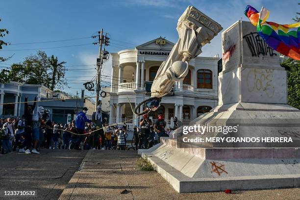 Protestors topple a statue of Christopher Columbus during a demonstration against government in Barranquilla, Colombia on June 28, 2021.