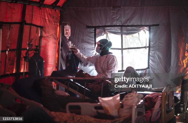 Medical personnel tend to Covid-19 patients in a tent set up outside a hospital in Bogor on June 29 as infections soar in Indonesia.