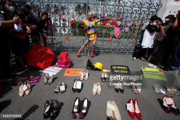 Nightlife worker activist from the Empower Foundation poses behind the shoes during a protest for financial assistance due to coronavirus disease...