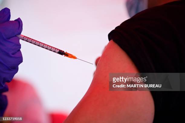 Man receives a dose of Comirnaty vaccine by Pfizer-BioNTech against Covid-19 on June 29, 2021 at an outdoor vaccination centre set up by the French...