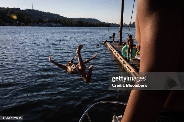 Swimmer dives into the Willamette River from a dock at Sellwood Riverfront Park during a heatwave in Portland, Oregon, U.S., on Monday, June 28,...