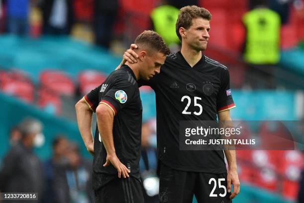 Germany's midfielder Joshua Kimmich and Germany's forward Thomas Mueller react to their defeat in the UEFA EURO 2020 round of 16 football match...